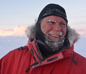Expeditioner standing smiling at camera with sea ice in background