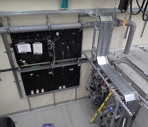 Industrial scene showing pipework and a black switchboard