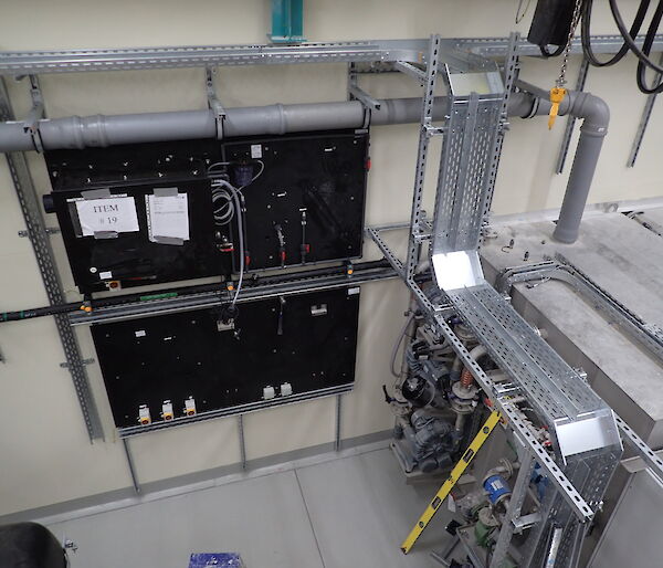 Industrial scene showing pipework and a black switchboard