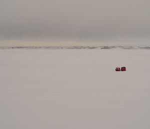 Red tracked vehicle in foreground and station in background