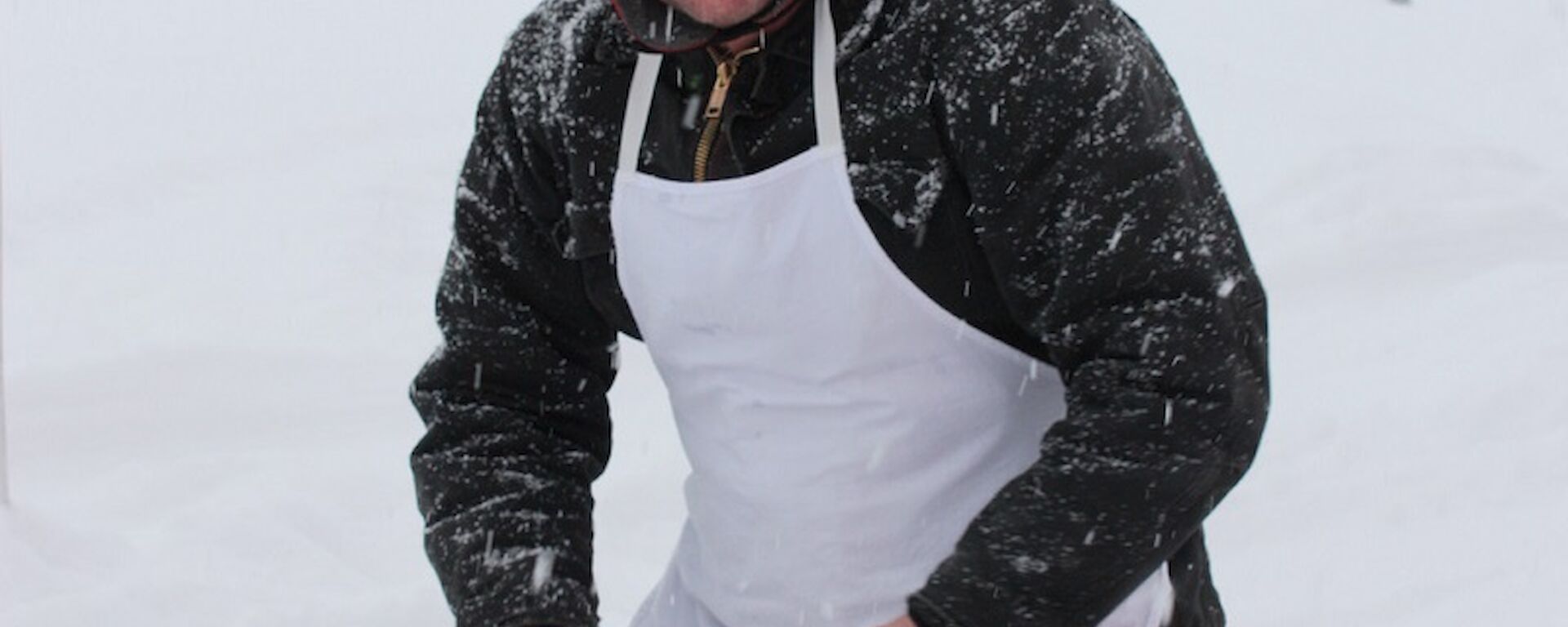 Expeditioner kneeling on a mat in the snow