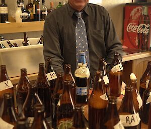 Expeditioner standing behind a range of homebrew beers