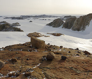 Steep slope in foreground down to sea ice and brown islands in background