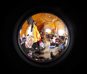 Fish eyed lens photo of expeditioners inside a rounded field hut