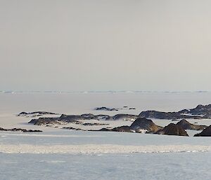 Panoramic photo of large glacier, sea ice and brown islands