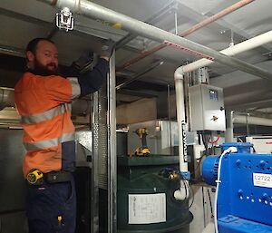 Expeditioner standing close to ceiling working on wiring