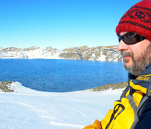 Expeditioner photographed in profile in foreground with lake in background