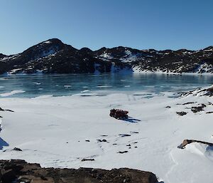 Elevated view of quads parked up on edge of sea ice next to rocky ravines