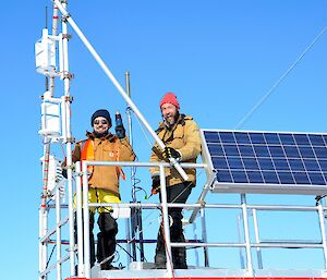 Two expeditioners standing on the roof of a container