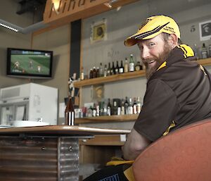 Expeditioner seated in front of a television turns smiling to face camera