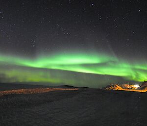 Green aurora shining over Davis station at night