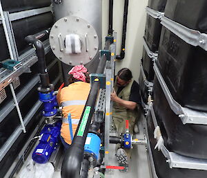 Expeditioners kneeling around a waste treatment plant during installation