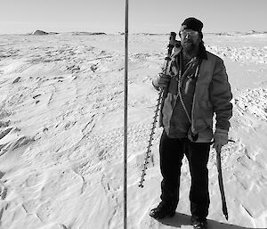 Expeditioner standing beside a cane marker facing camera