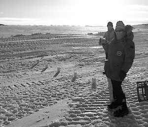 Expeditioner standing on snow holding a glass of beer