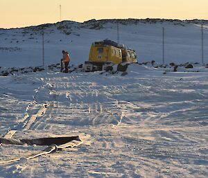 Expeditioner hauling a hose in the background with an empty hose on ground in foreground