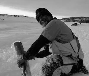 Expeditioner facing camera smiling with water hose in hand