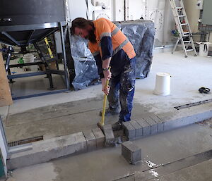 Expeditioner hammering bricks out of concrete work