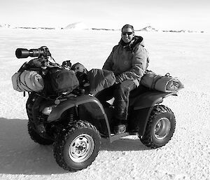 Expeditioner seated on a quad bike smiling