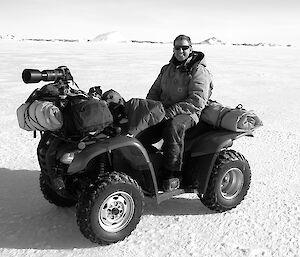 Expeditioner seated on a quad bike smiling