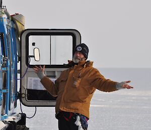 Expeditioner standing beside a quad with an ice plateau in background