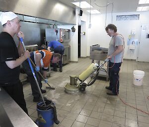 Expeditioners with brooms and buckets in the kitchen
