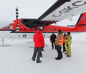 Expeditioners and newly arrived air crew meet beside an aircraft