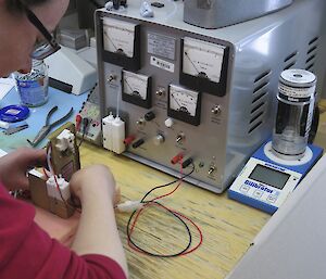 Expeditioners sitting at a desk preparing equipment prior to a balloon launch