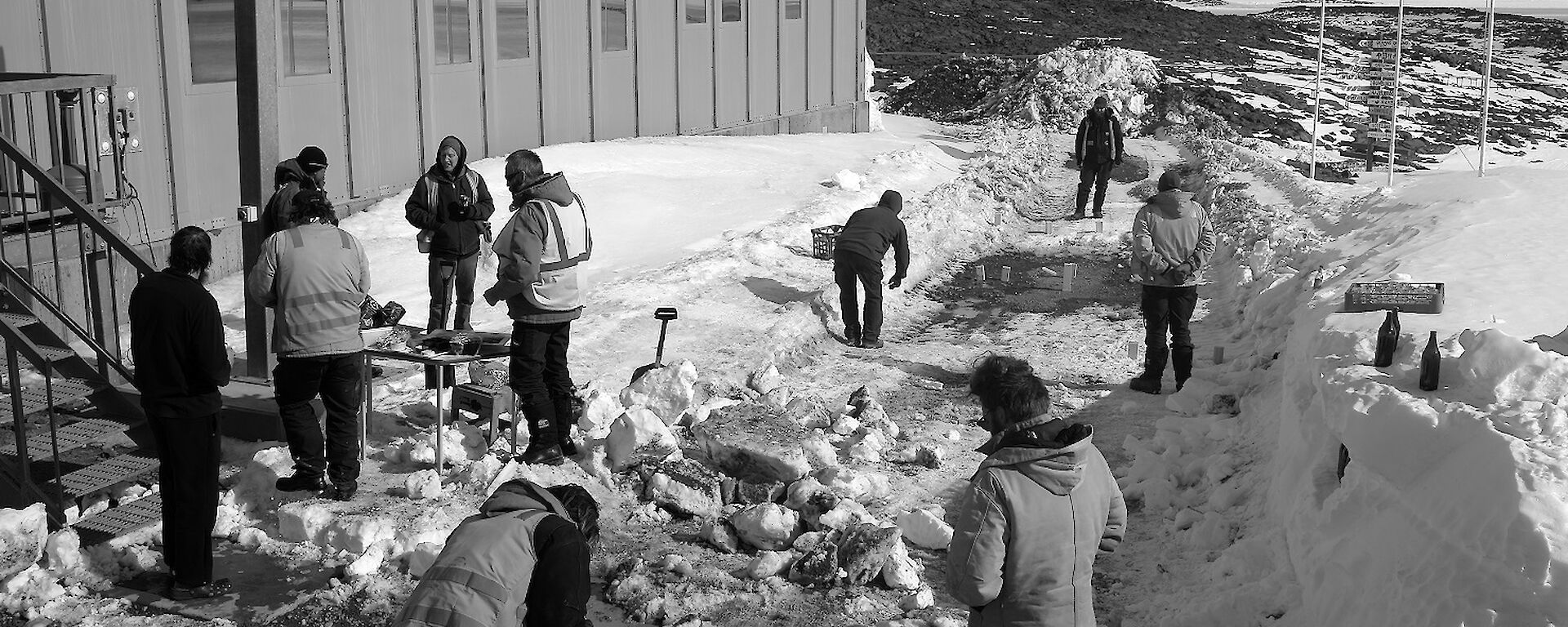 Expeditioners gathered outside a building playing games and talking