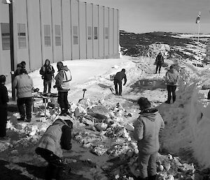 Expeditioners gathered outside a building playing games and talking