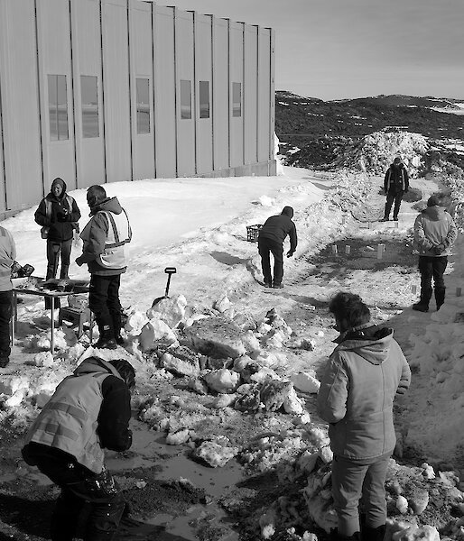 Expeditioners gathered outside a building playing games and talking
