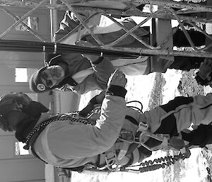 Expeditioner dressed in protective clothing standing beside a communications tower