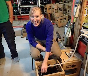 Female expeditioner filing beer bottles