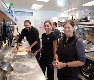 Three expeditioners taking cooking lessons in the kitchen