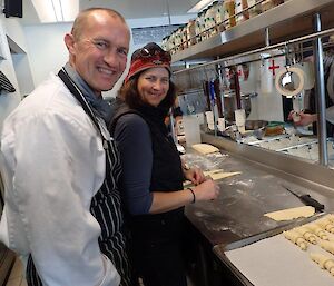 The chef showing a female expeditioner how to cook