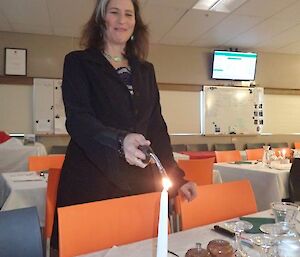 A female expeditioner lighting candles on the dinning tables