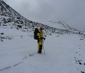 A female expeditioner walking over the snow terrian