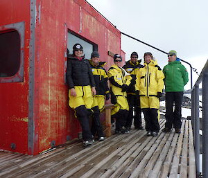 Expeditioners on the veranda of a field hut.