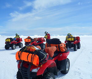 Expeditioners on quad bikes riding on the sea ice