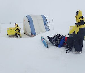 A tent erected on the sea with two expeditioners nearby