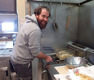 An expeditioner cooking chips in a deep fry