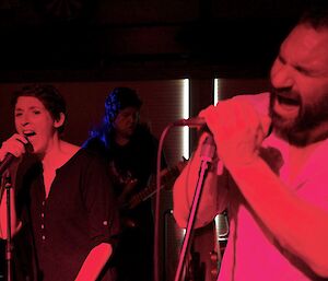 A male and female expeditioners singing a song on stage