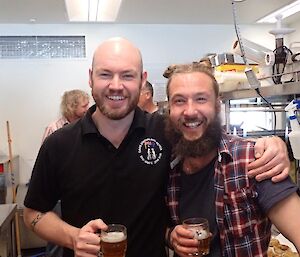 Two expeditioners relaxing with a beer after cooking the in the kitchen