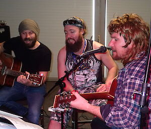 Three expeditioners singing a song on stage