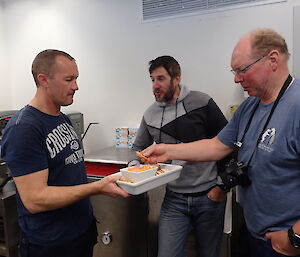 An expeditioner being served some food by the chef