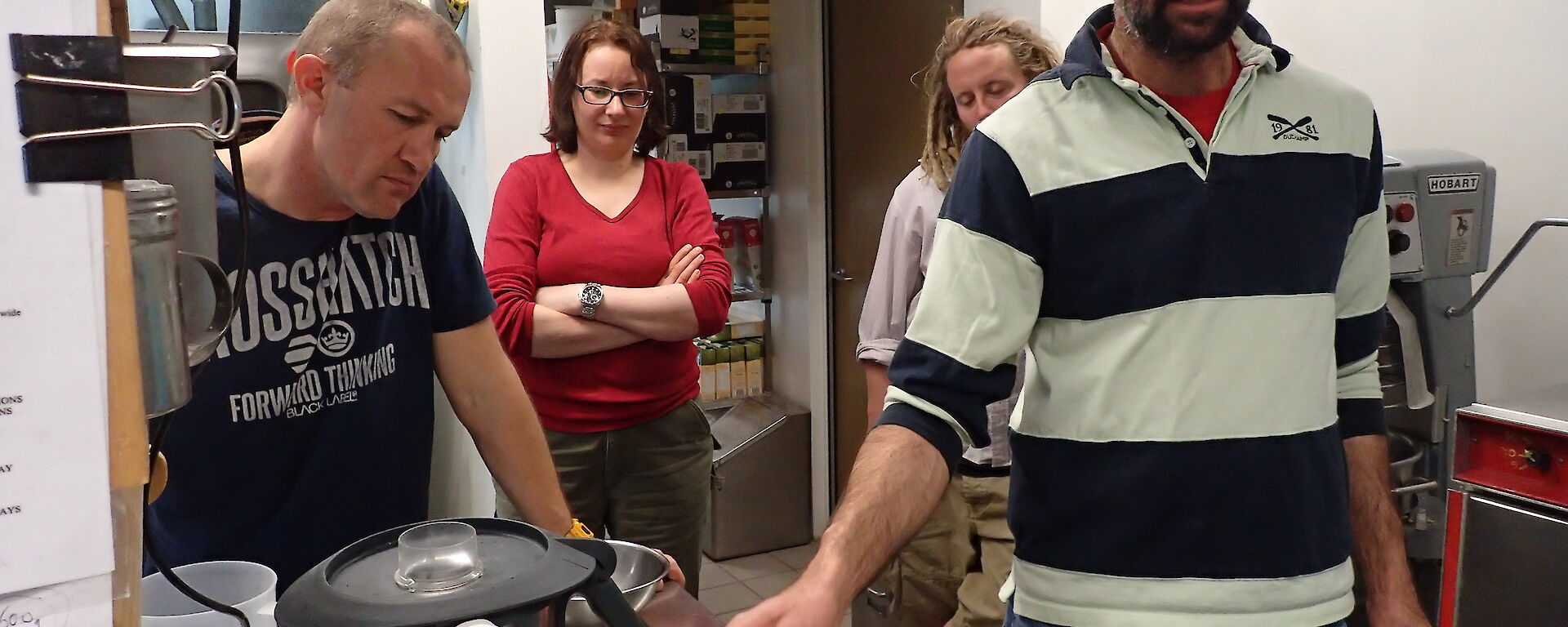 Two expeditioners examining a Thermomix machine