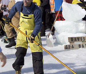 An expeditioner scooping newlt formed ice from a ice hole