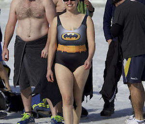 A female expeditioner in a bat girl outfit ready to have a summer swim in an ice hole