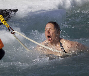 A shocked expression on a female expeditioner’s face as she comes out of freezing cold water