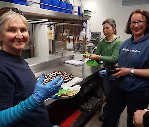 Three female expeditioners making rum balls in the kitchen