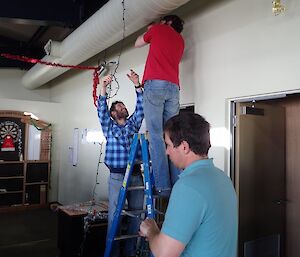 Two expeditioners putting up Christmas decorations